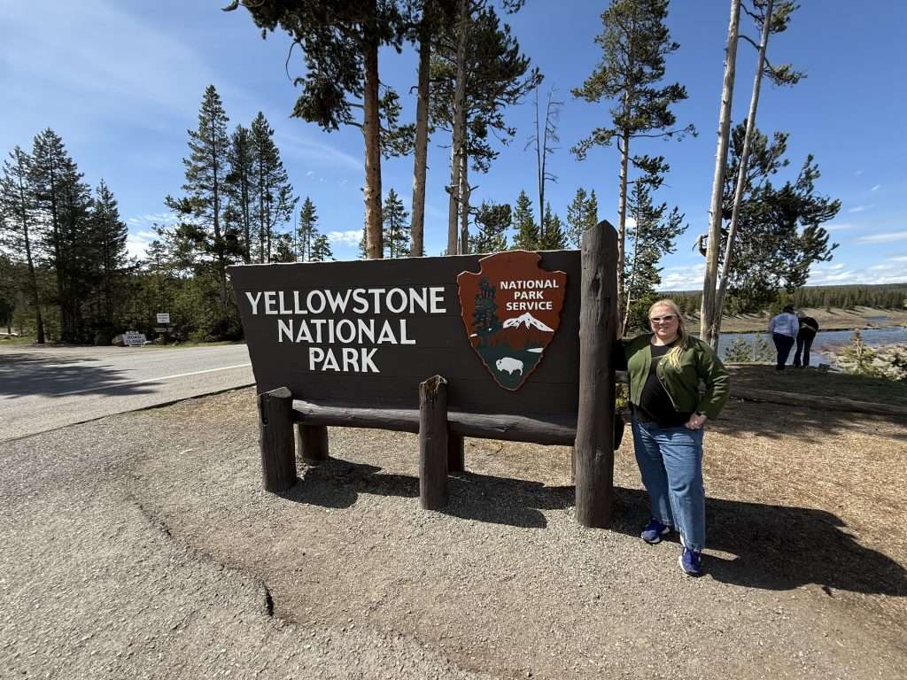 Jenn Lloyd At Yellowstone National Park Entrance Sign One Day In Yellowstone From Jackson Hole